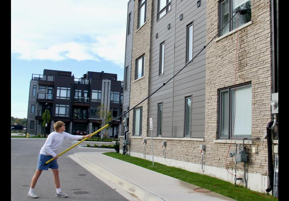 Cleaning fourth-storey windows with a water-fed pole