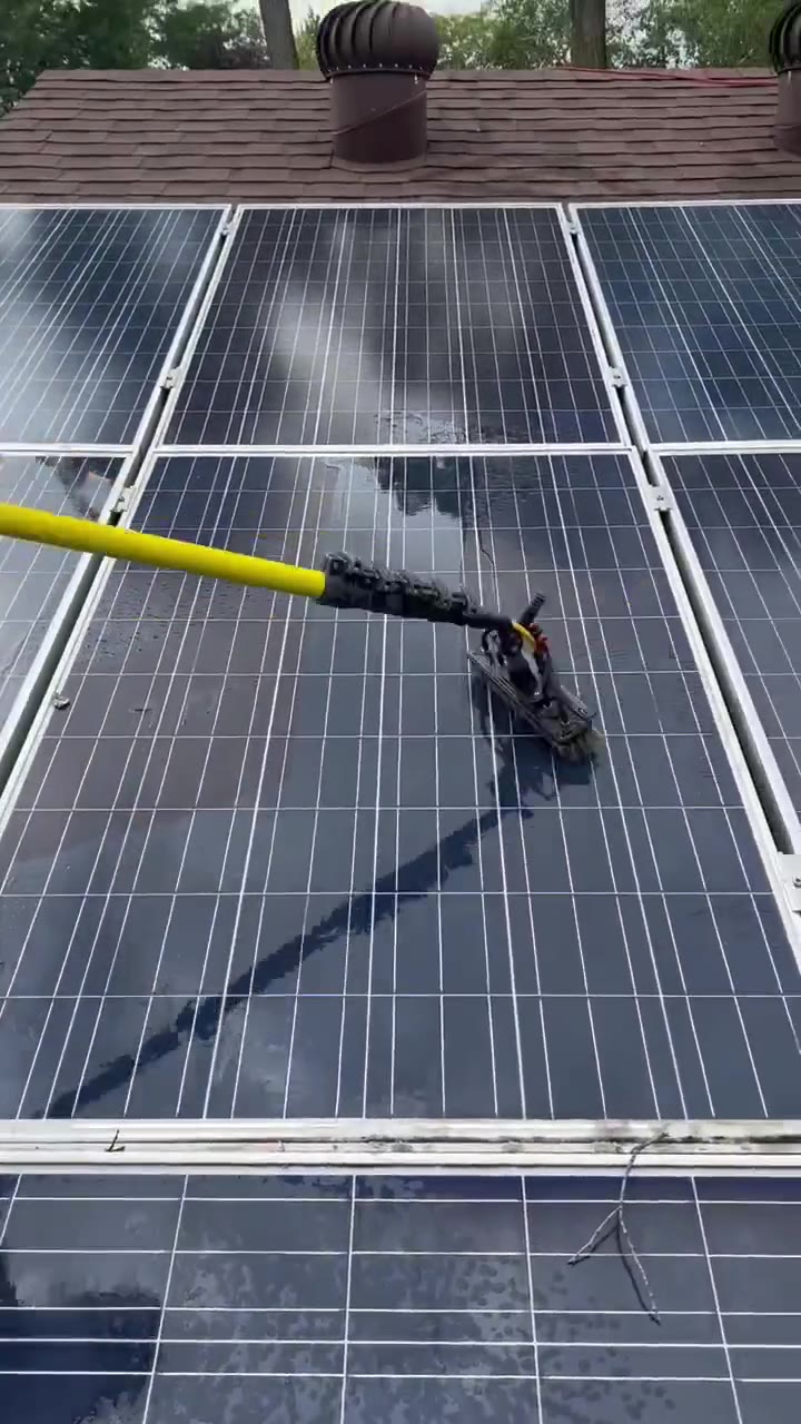 Water-fed brush scrubbing rooftop solar panels